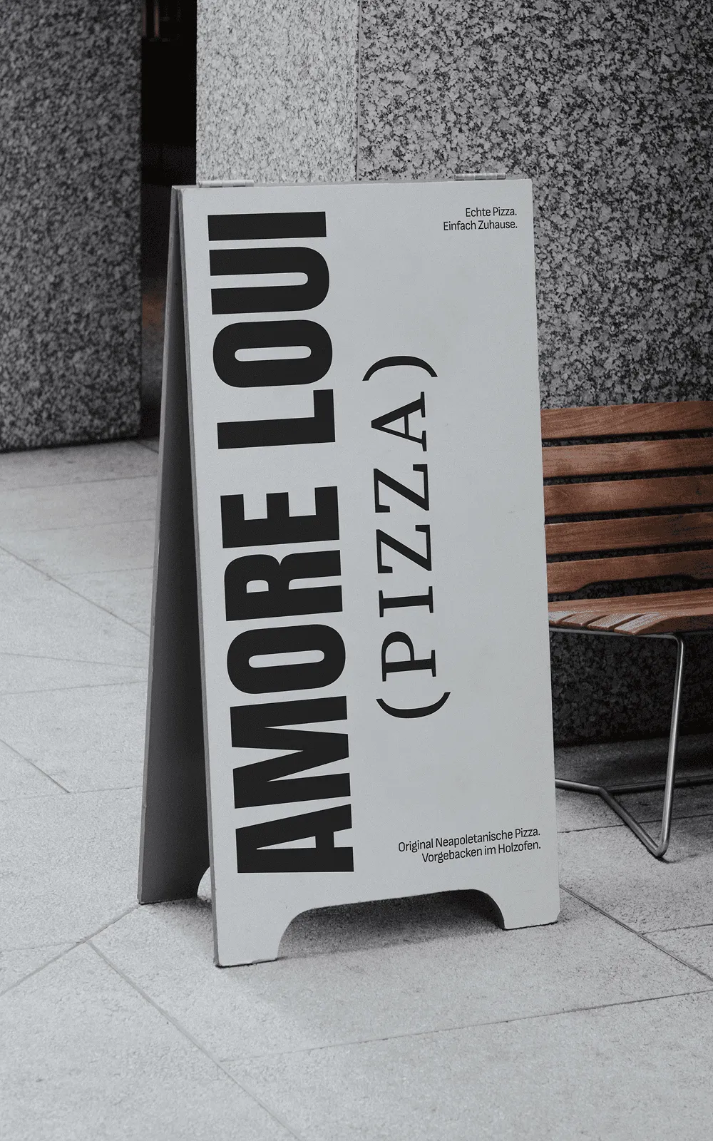 Amore Loui Kundenstopper auf dem Gehweg mit vertikaler Signatur
