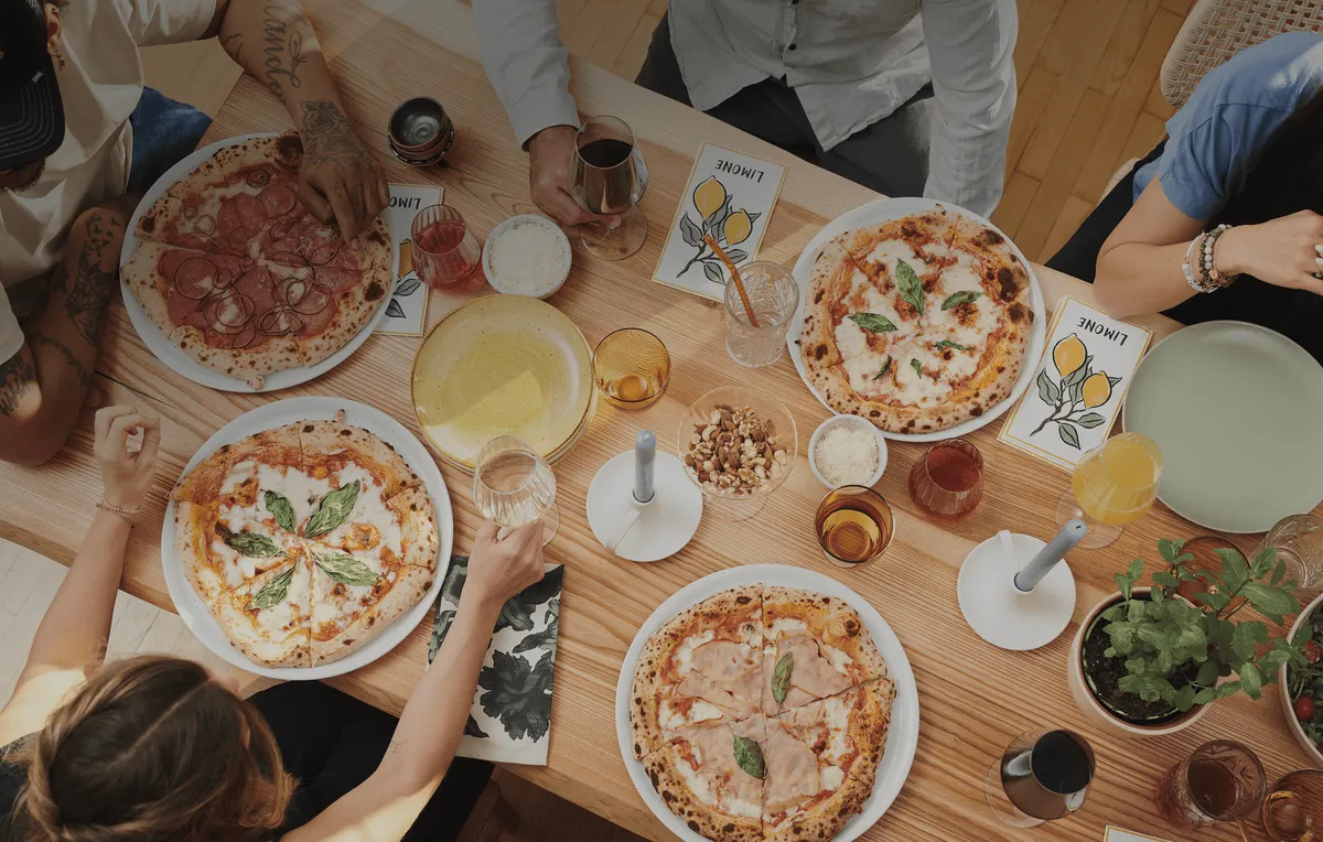 Neapolitanische Pizzen, Getränke und Amore Loui Speisekarten auf einem gemeinsamen Tisch, von oben